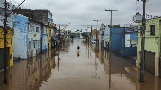 Ein Mann watet am Freitag, den 3. Mai 2024, in Porto Alegre im brasilianischen Bundesstaat Rio Grande do Sul durch ein von schweren Regenfällen überschwemmtes Gebiet. 